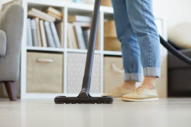 Vrouw stofzuigt vinyl vloer: een van de meest onderhoudsvriendelijke vloeren