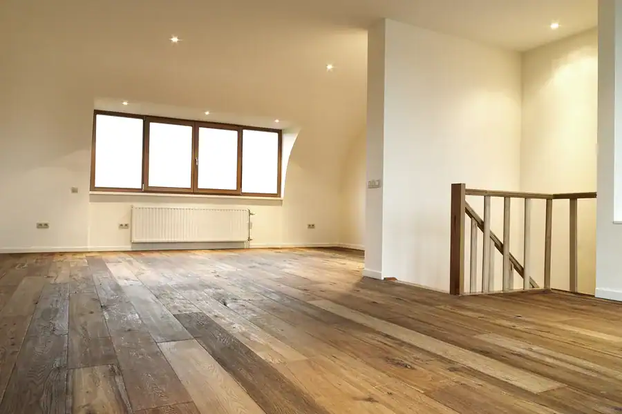 Nieuwe houten vloer in moderne woonkamer als alternatief voor vloerrenovatie