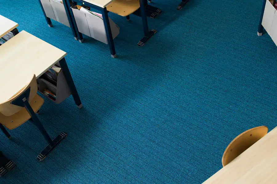 Donkerblauw projecttapijt in een kantooromgeving, voorbeeld van het brede assortiment vloerbedekking voor zowel particulier als project