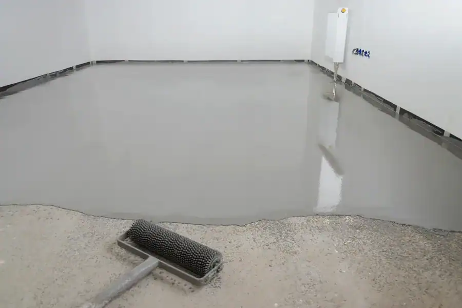 Egaline vloeit uit over een betonnen ondergrond met een prikroller op de voorgrond