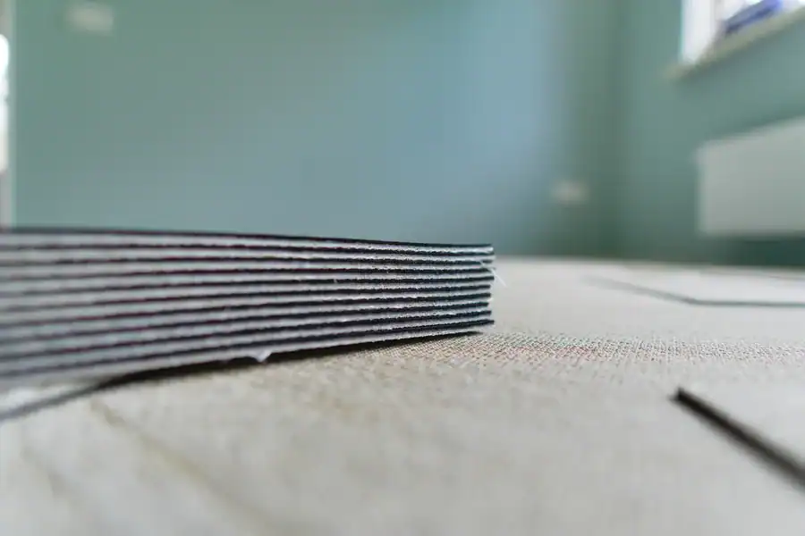 Close-up van een stapel ondervloerplaten die klaarliggen om onder een PVC-vloer te leggen